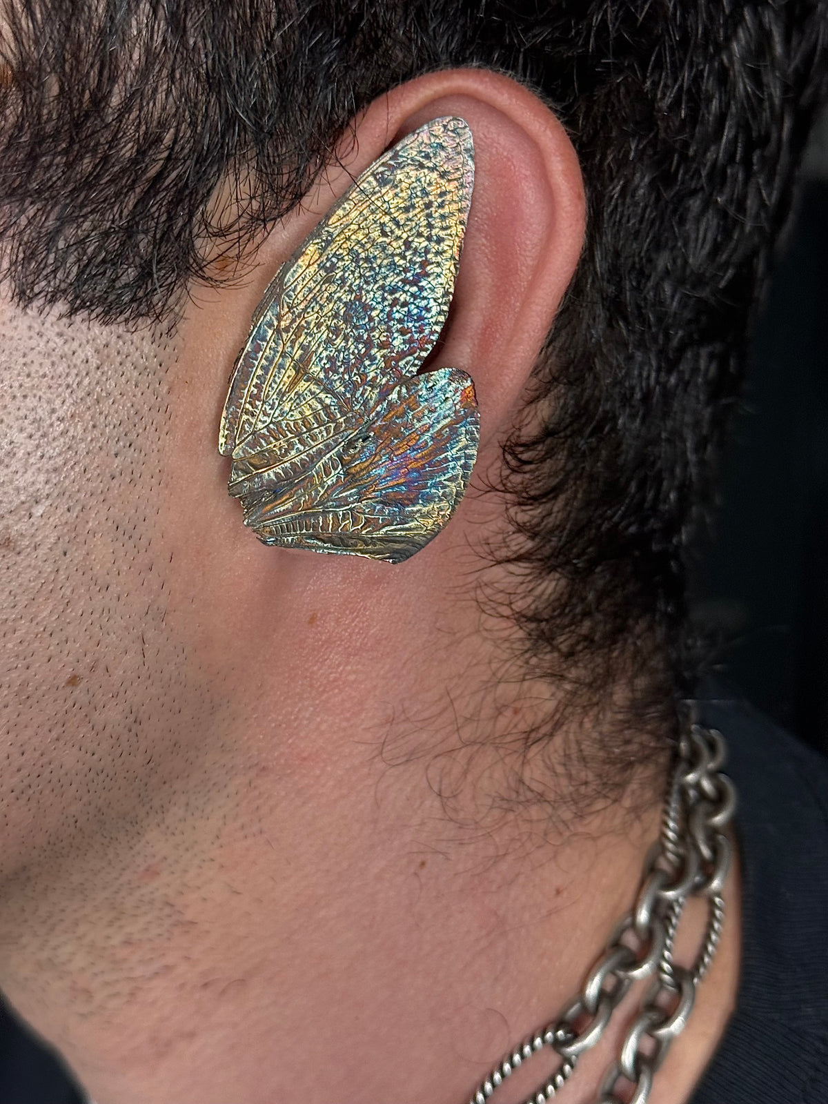 Cicada wing fossil ear cuff by HAFT in rainbow patina, worn at the ear
